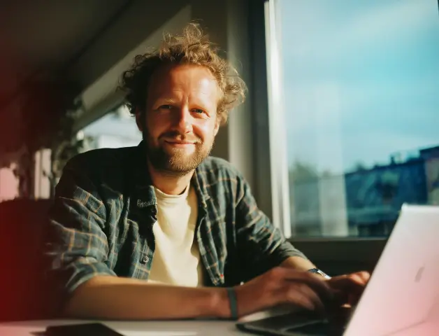 junger Mann sitzt vor einem Laptop