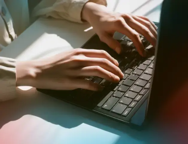 die Hände einer Frau tippen auf der Laptoptastatur